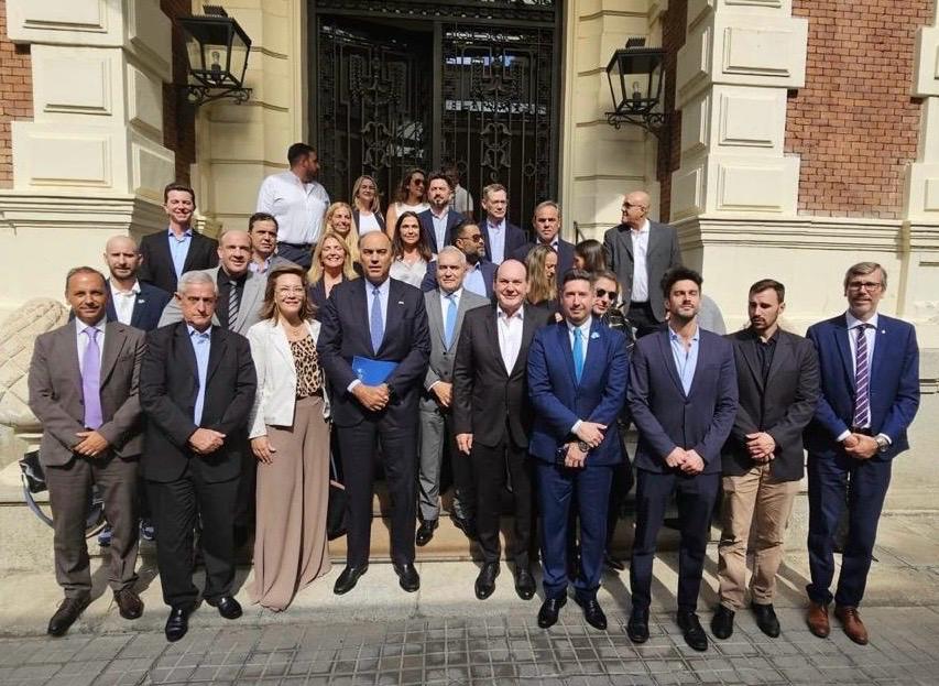 Foto grupal en la escalinata de un edificio público al término de un encuentro institucional.