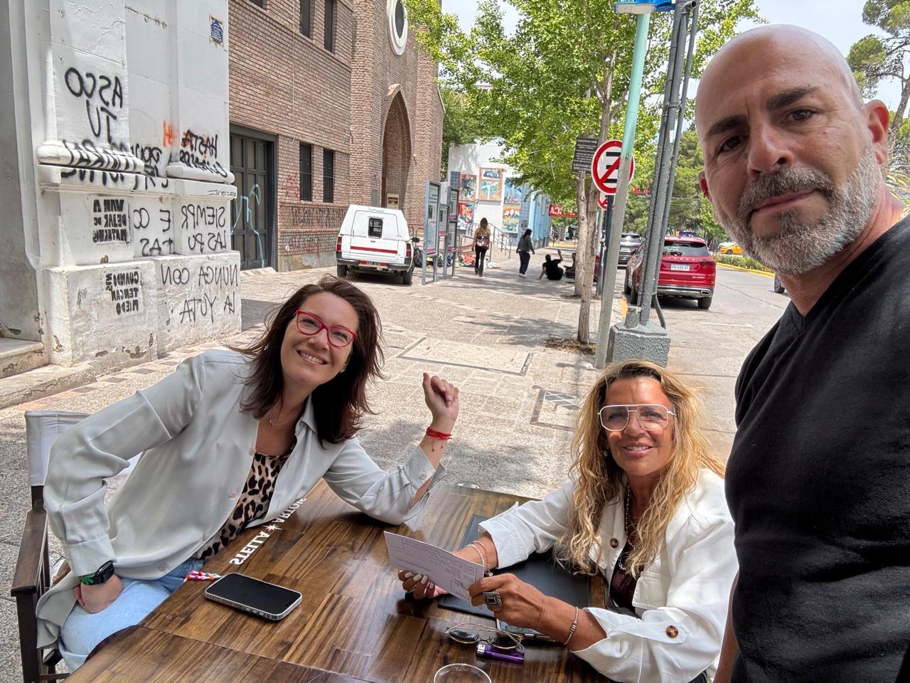 Reunión de trabajo en la mesa de un bar céntrico, repasando documentación.